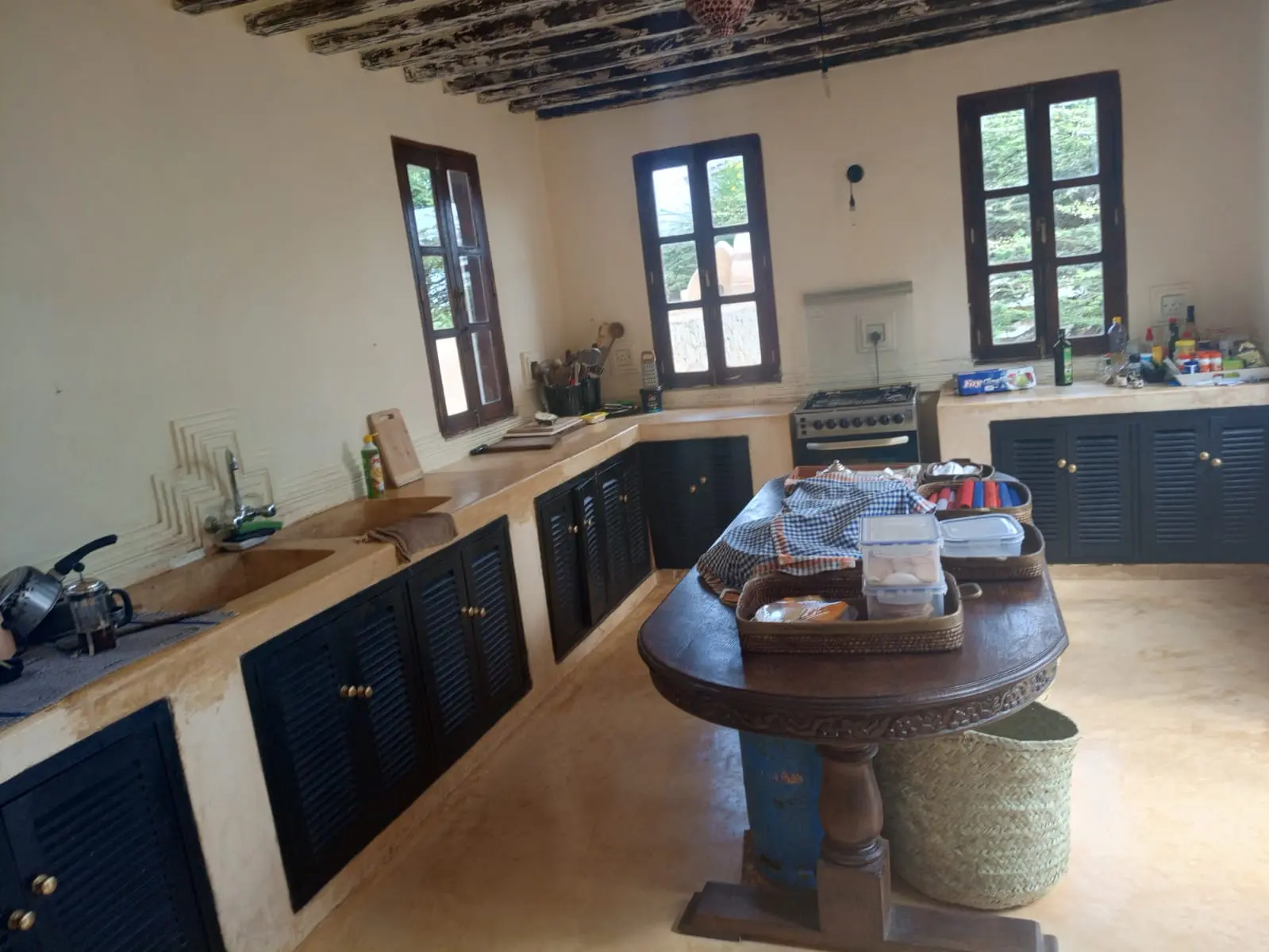 Traditional kitchen with wooden countertops, blue shuttered cabinets and round table